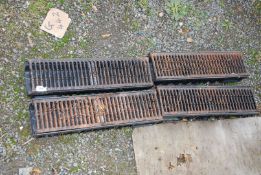 Four plastic drainage channels with cast iron gratings.