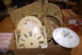 A quantity of brass, enamel and wooden clock faces and surrounds.
