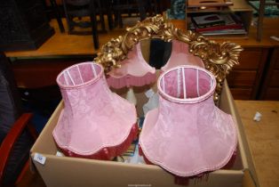 A gilt framed mirror and two table lamps.