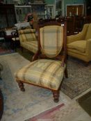 An Edwardian Mahogany framed lady's fireside chair standing on turned front legs and similarly