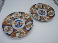 A pair of Oriental hand finished chargers incorporating Japanese figures and flowers and with blue
