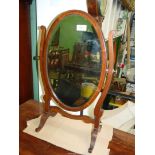 A 19th century oval Mahogany Swing toilet Mirror with bevelled glass on scroll frame,