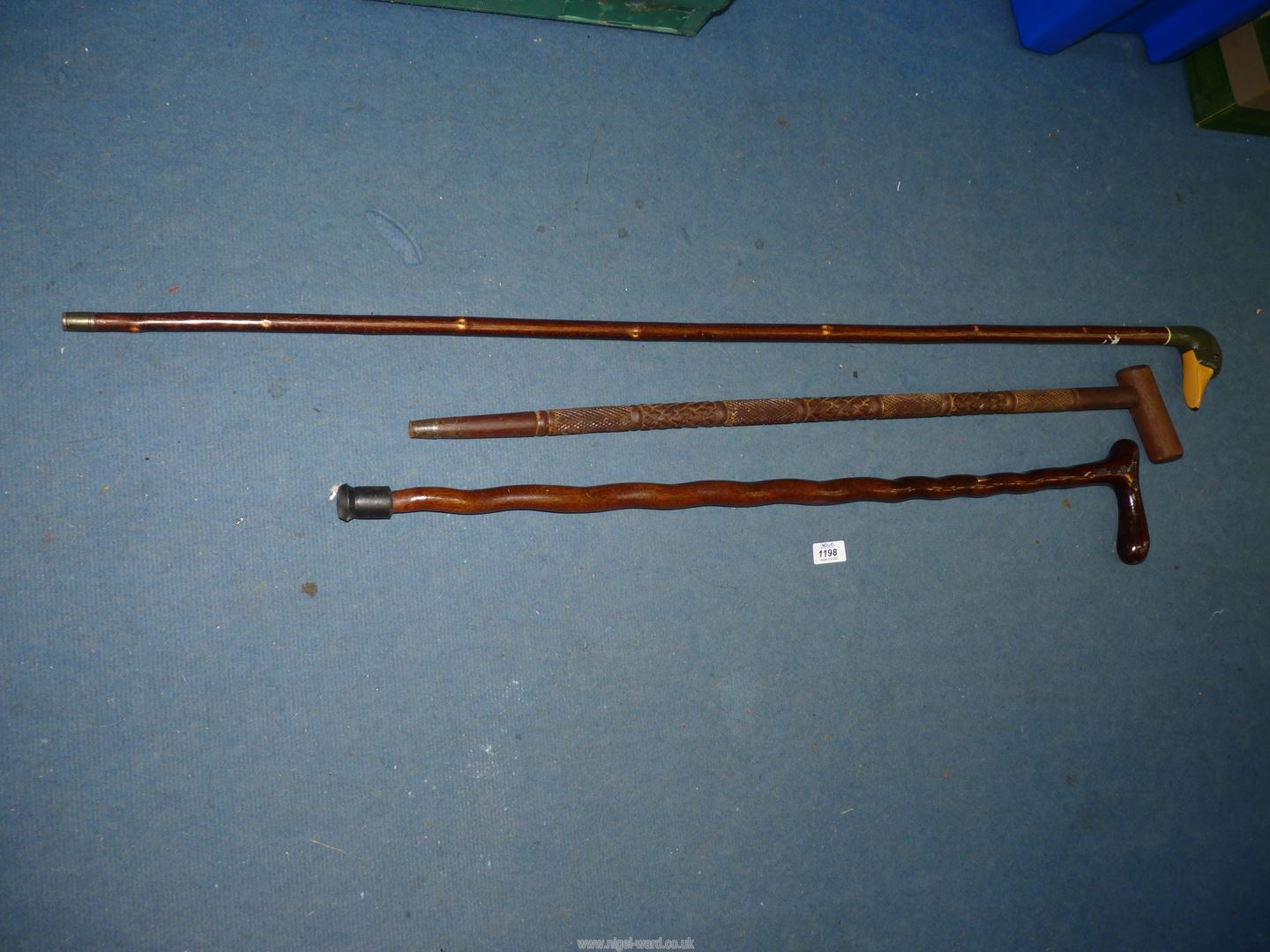 Three walking sticks, one with carved duck head,