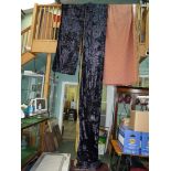 A pair of navy blue crushed velvet curtains with gold coloured linings,