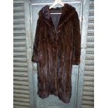 A lady's dark brown Mink Coat with shawl collar and hook fastening.