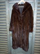 A lady's dark brown Mink Coat with shawl collar and hook fastening.