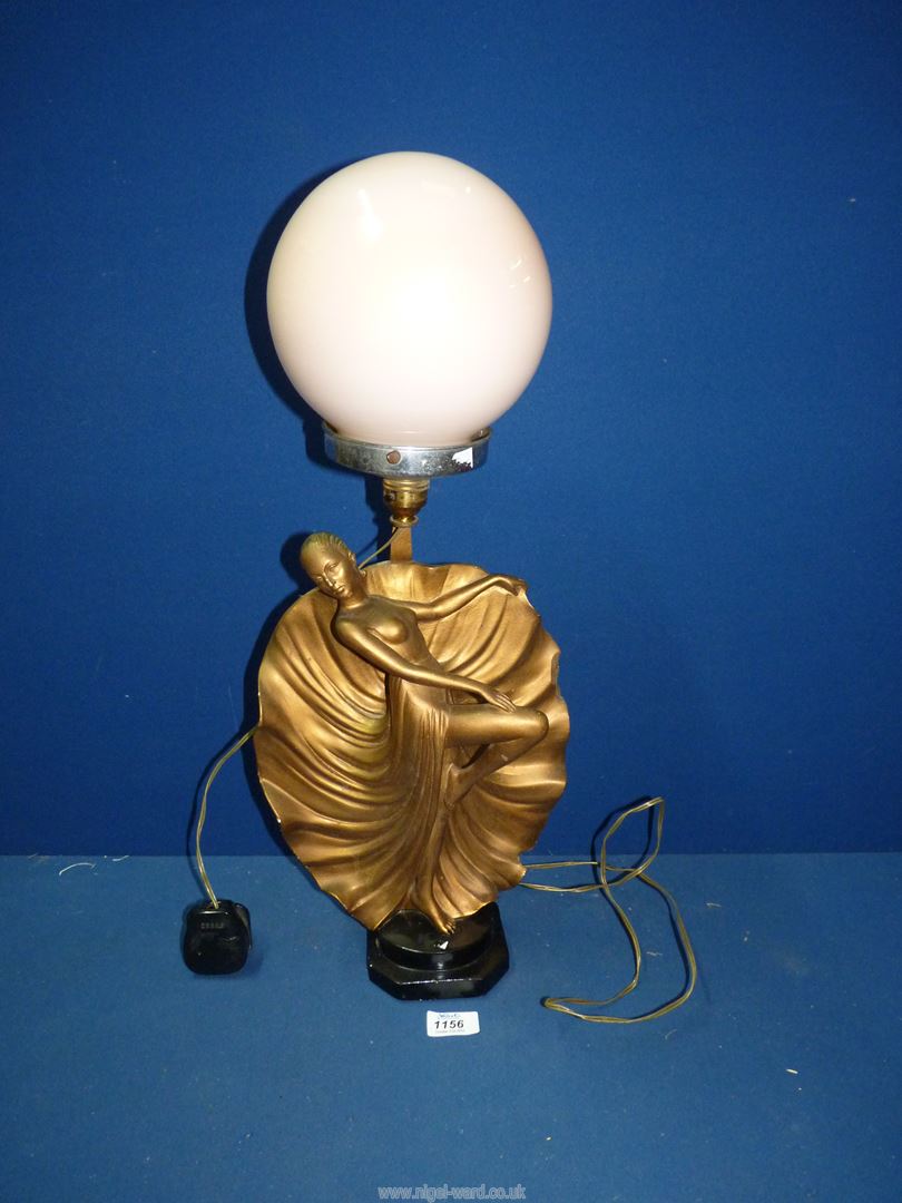An Art Deco figure lamp having peach globe shade, 23" tall.