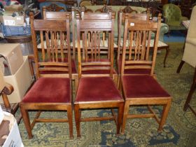 A set of six Oak framed dining chairs having maroon velvet type upholstered drop-in seats.