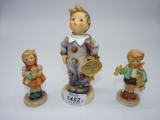 A Goebel Boy figure with toy horse and trumpet, Girl with doll and Boy in clowns costume.