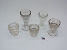 A small quantity of antique illusion glasses including two toast makers,penny lick,shot glasses etc.