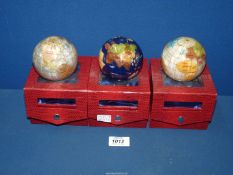 Three small mineral globe Paperweights of the world, boxed.