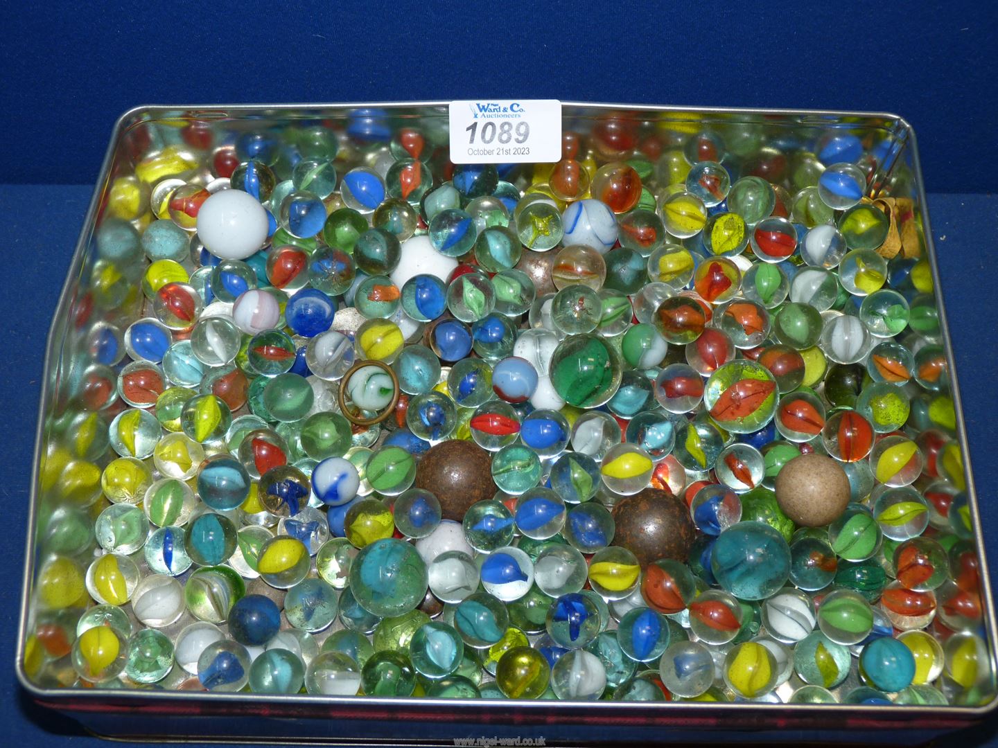 A tin of Marbles including stone, steel, white, blue, etc.