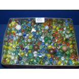 A tin of Marbles including stone, steel, white, blue, etc.