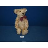 A jointed Steiff Teddy bear with squeaker and tartan bow, 12 1/2'' tall.