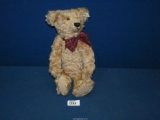 A jointed Steiff Teddy bear with squeaker and tartan bow, 12 1/2'' tall.