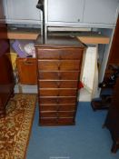 A most useful narrow Oak chest of nine short drawers with Art Deco design drop handles,