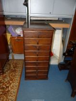 A most useful narrow Oak chest of nine short drawers with Art Deco design drop handles,