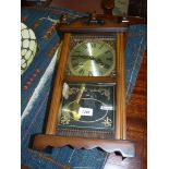 A cased 31 day chiming wall Clock having decorative brass corners around the face,