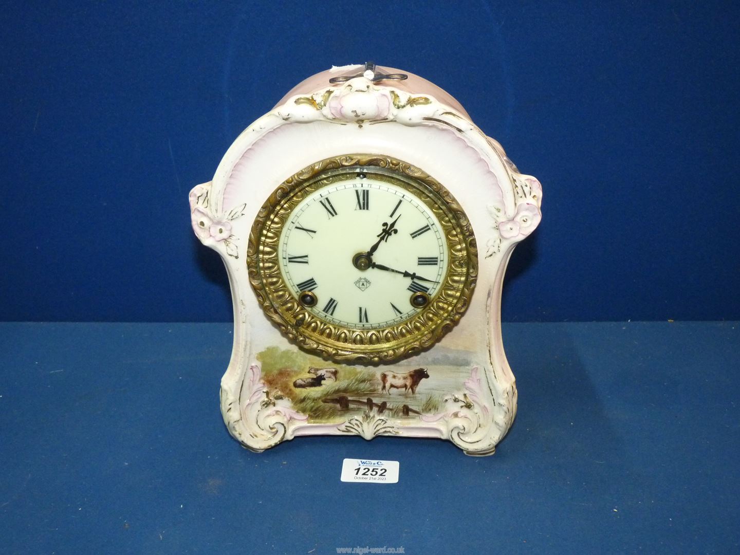 An Ansonia chiming Mantle Clock with Bonn china casing having Roman numerals to the cream face and