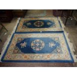 A pair of Oriental patterned hearth rugs having central panel of blue with stylised floral detail