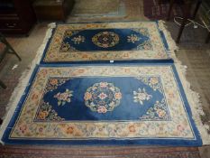 A pair of Oriental patterned hearth rugs having central panel of blue with stylised floral detail