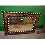 A rectangular Wall Mirror with ebonised wood frame inlaid with other woods in floral design with