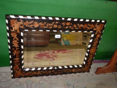 A rectangular Wall Mirror with ebonised wood frame inlaid with other woods in floral design with