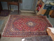 A navy/red/cream and floral patterned rug, 56" x 92".