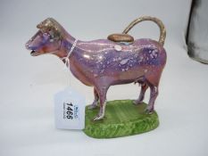 An unusual Dilwyn Swansea pink copper lustre cow creamer on green base,