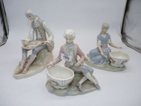 A pair of Lladro figures of a girl and boy sitting by large jardinieres,