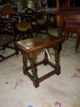 A reproduction solid Oak joynt stool standing on turned legs united by perimeter stretchers,