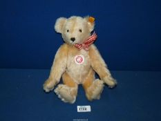 A Steiff jointed Teddy bear with red and white ribbon.