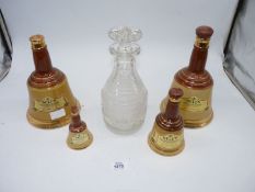 Four Wade Whisky bells and a cut glass decanter with hobnail and ring design.