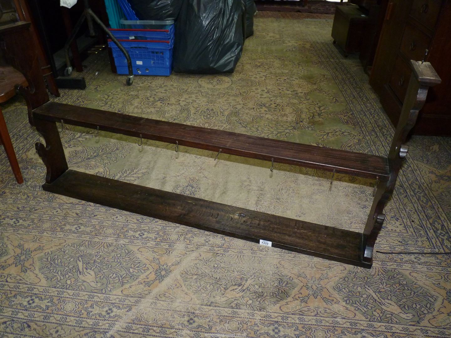 An Oak wall-hanging rack/shelves having fret-worked ends and fitted with a number of cup-hooks.