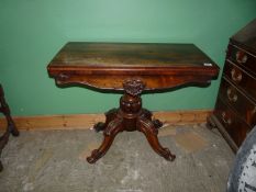 A 19th century Rosewood flap-over card table standing on a heavy turned and lobed pillar with four