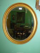 An early 19th century oval gesso Mirror with bead decoration, 25 1/2" x 22 1/2".