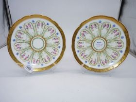 A pair of Mintons cabinet plates having painted swags of roses and cornflowers with shaped wide