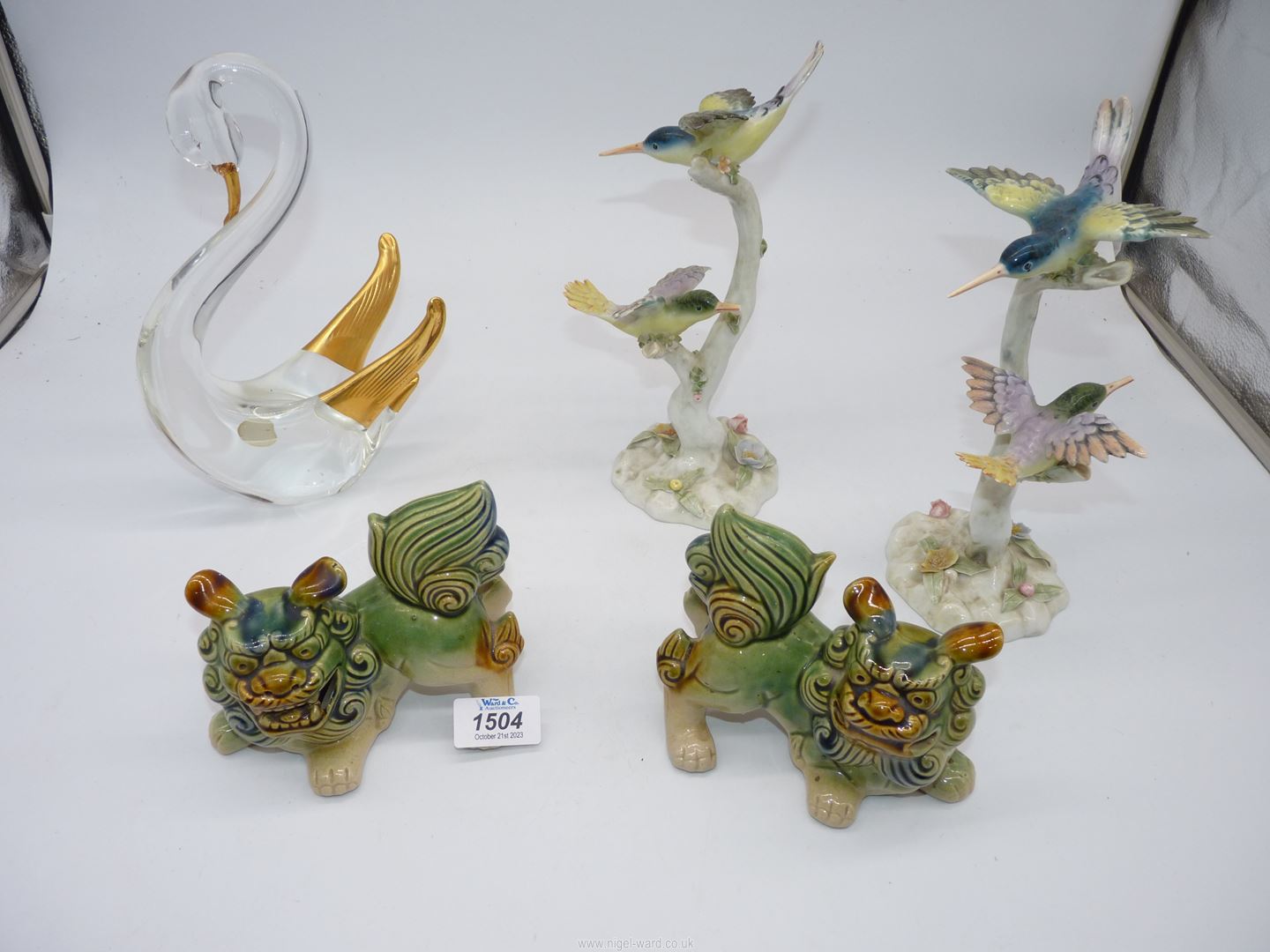 A pair of continental china models of birds on branches (beaks chipped),