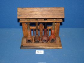 An oak four bay Pipe Rack, fashioned as a roofed lych gate holding three briar pipes, etc.