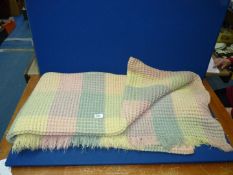 A single Welsh wool waffle blanket, yellow/pink/green.