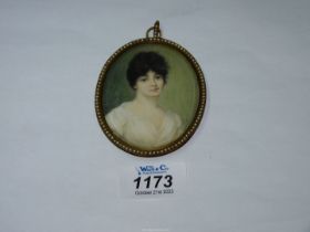 An oval framed miniature of a dark haired lady in peasant style blouse,
