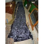 A pair of navy blue crushed velvet curtains having gold coloured linings.