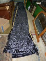 A pair of navy blue crushed velvet curtains having gold coloured linings.