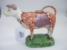 A 19th century Dilwyn Swansea pottery cow creamer decorated in red oxide with pink lustre 'belt'