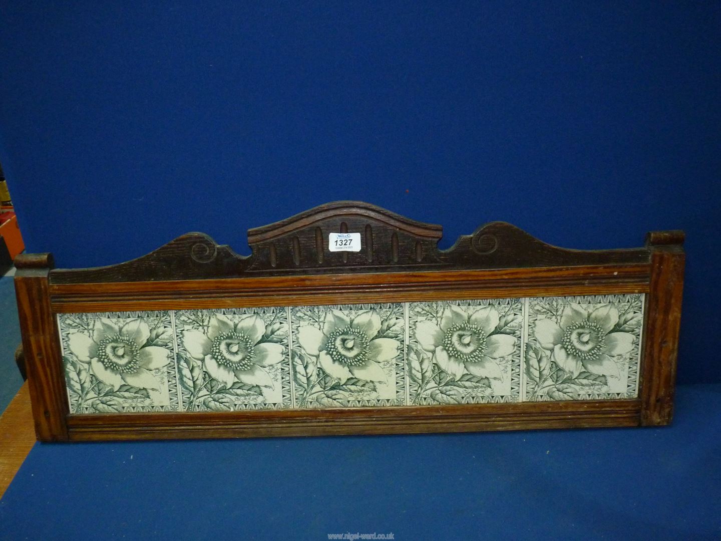 A Pine framed upstand with shaped pediment and set with five green and white tiles depicting flower