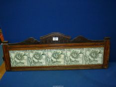A Pine framed upstand with shaped pediment and set with five green and white tiles depicting flower