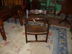 A Mahogany framed open armed armchair having a floral and leaf-scroll decorated top rail,