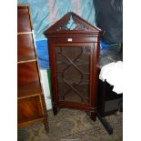 An elegant Mahogany wall cabinet having cross-banding and a dentil frieze the pediment with