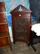 An elegant Mahogany wall cabinet having cross-banding and a dentil frieze the pediment with