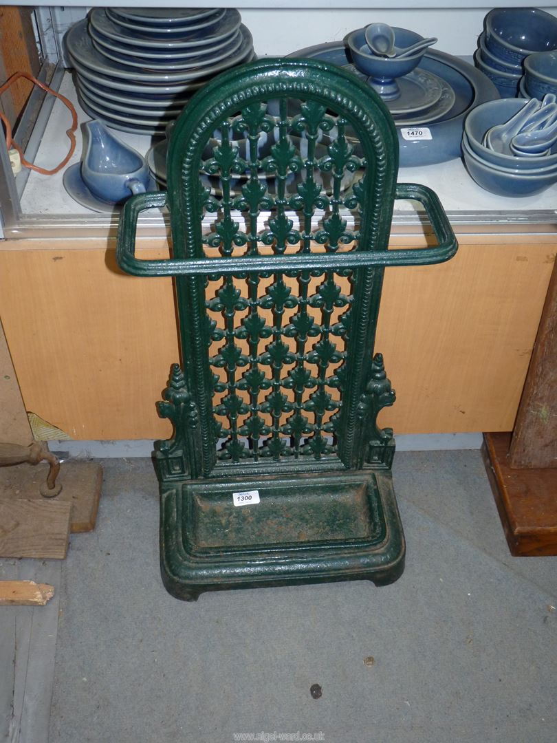 A green vintage cast iron umbrella stick stand.